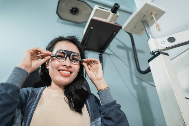 uma bela mulher posa segurando óculos de medição que estão sendo usados - Foto, Imagem