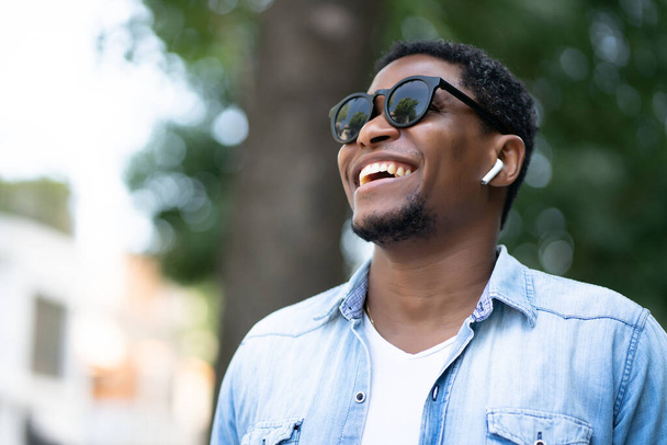 Africký Američan se usmívá při chůzi venku. - Fotografie, Obrázek