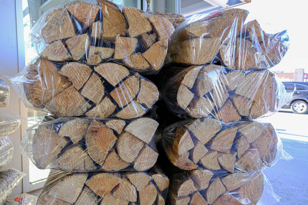 Pile of Shrink wrapped firewood on display at a supermarket - Photo, Image
