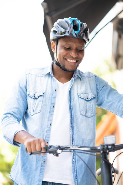 Man wearing a helmet while walking with a bicycle. - Фото, зображення