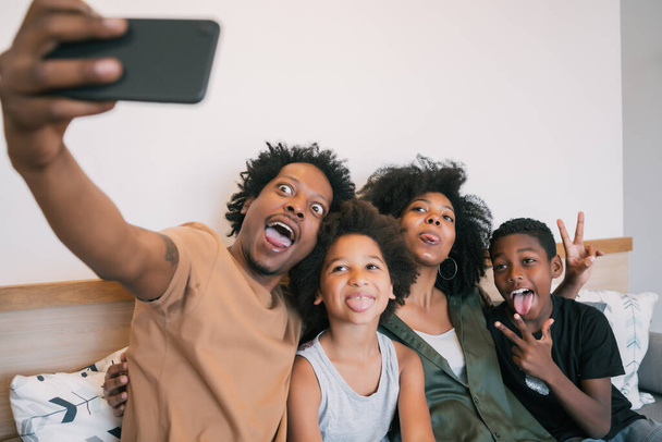 Family taking selfie together with phone at home. - Foto, afbeelding