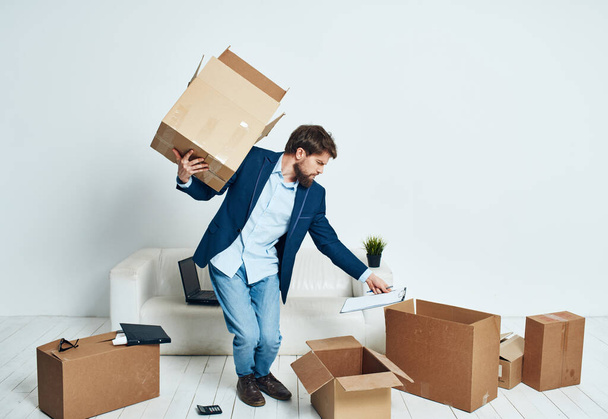 ein Mann mit einer Schachtel voller Dinge beim Auspacken eines neuen Arbeitsplatzes - Foto, Bild