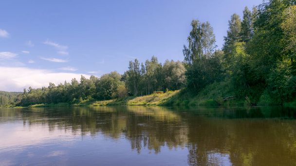 prachtige ochtend aan de rivier, reflecties van de bomen en de oever in het water, Gauja rivier, Letland - Foto, afbeelding