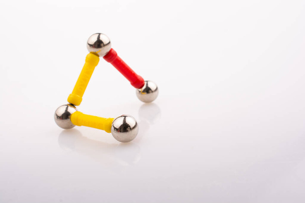 Магнітні іграшкові смужки та магнітні кульки на білому тлі
 - Фото, зображення