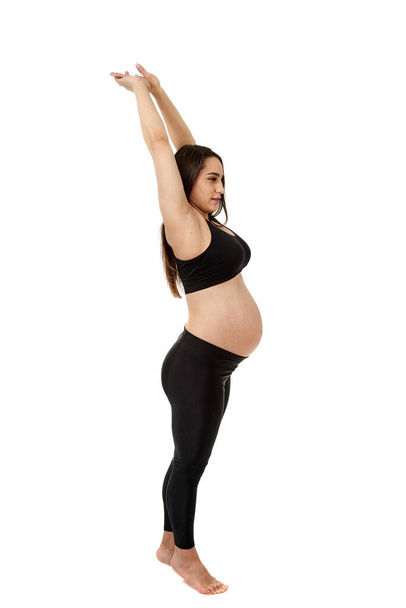 Young pregnant woman doing fitness exercises for pregnancy, isolated on white background - Фото, зображення