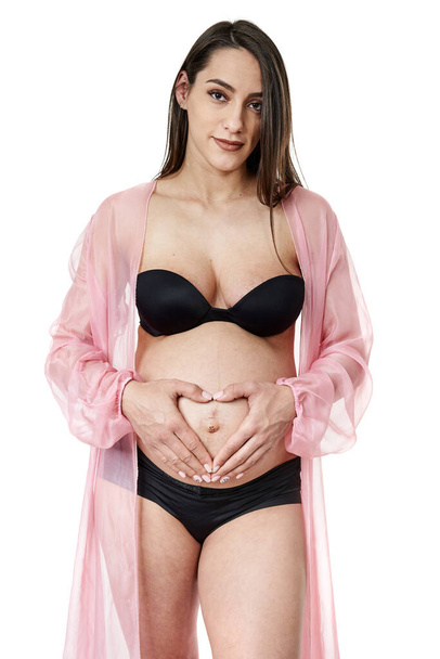 Pregnant woman in black underwear posing isolated on white background - Photo, image