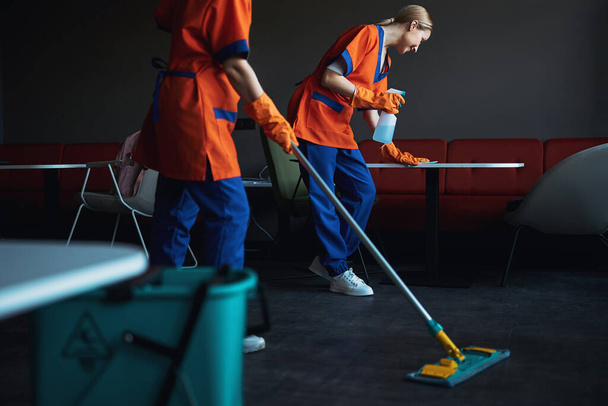 Dos limpiadores profesionales ordenando la cafetería de la oficina - Foto, imagen
