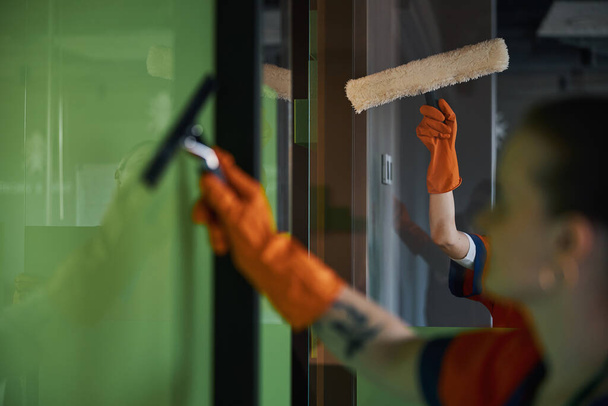 Рабочие, использующие микроволокно скруббер и скребок во время уборки - Фото, изображение