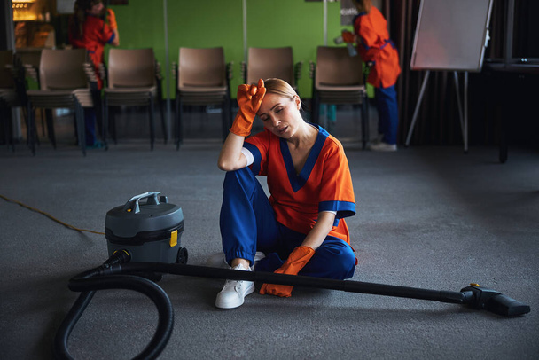 Femme de nettoyage épuisée se reposant après l'aspirateur - Photo, image