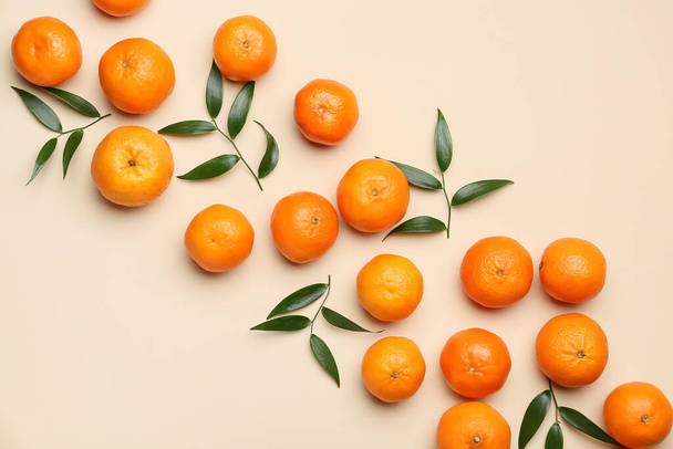 Összetétel édes mandarinnal és levelek színes háttéren - Fotó, kép