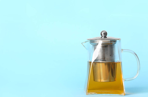 Teekanne mit heißem Tee auf farbigem Hintergrund - Foto, Bild
