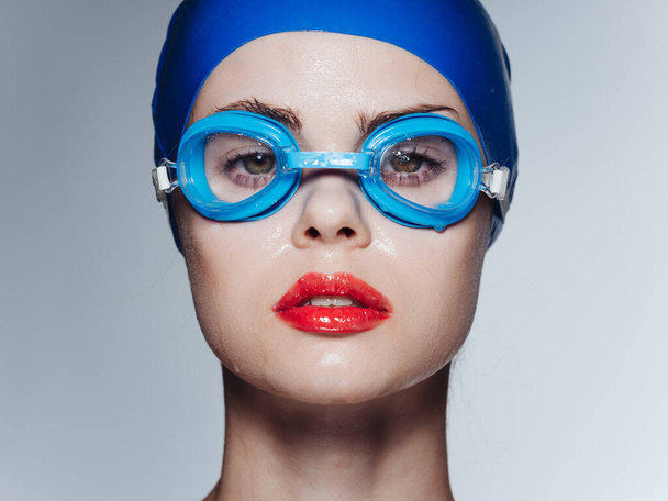 Woman with swimming goggles and blue cap cropped view - Photo, Image