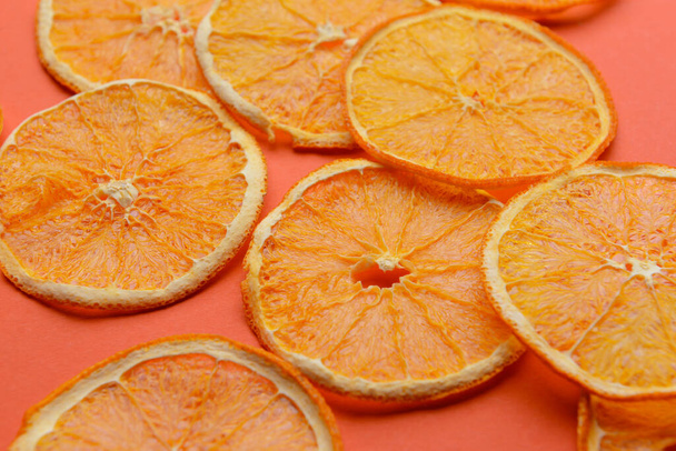 Gedroogde sinaasappelschijfjes op kleur achtergrond - Foto, afbeelding