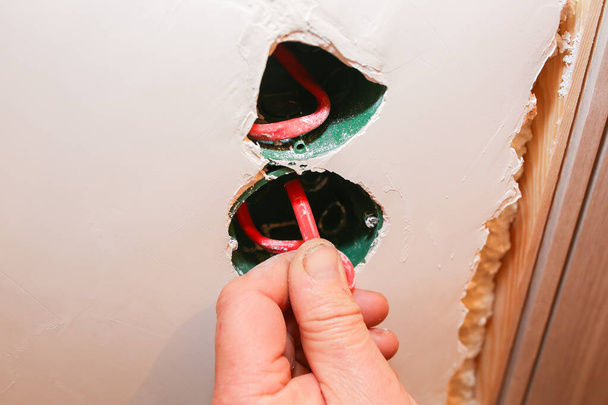 Buracos na parede com fios coloridos para interruptores de tomada. Reparação de manutenção obras de renovação no apartamento. Restauração dentro de casa. - Foto, Imagem