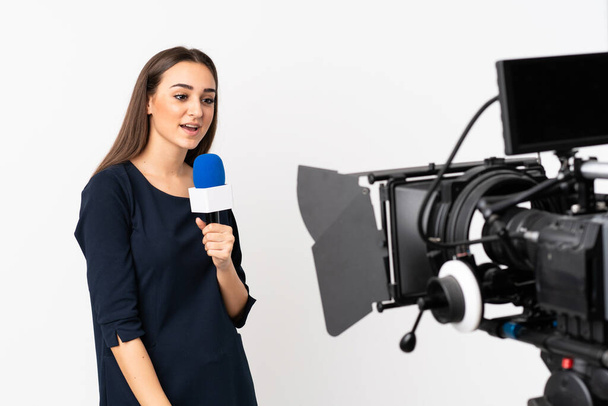 Reporter woman holding a microphone and reporting news isolated on white background - Foto, imagen