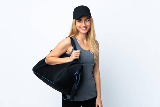 Young blonde woman holding a sport bag over isolated white background - Foto, imagen