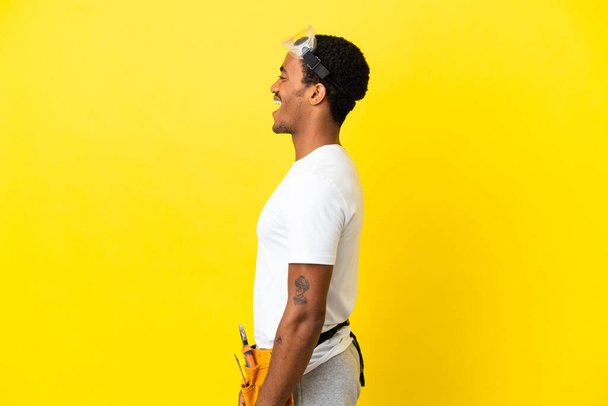 elettricista afroamericano uomo oltre isolato muro giallo ridere in posizione laterale - Foto, immagini