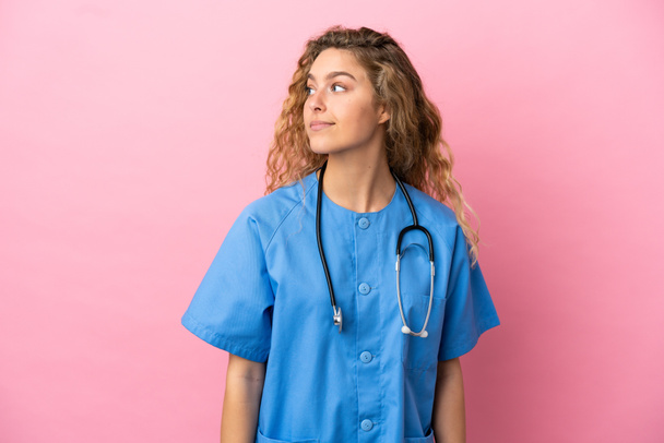 Young surgeon doctor woman isolated on pink background looking to the side - Foto, immagini