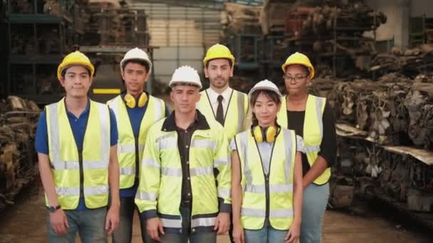 制服やヘルメットのエンジニアの様々な民族が立っている、腕を横断し、喜んで笑顔。すべての同僚は、機械スペアパーツ倉庫工場での専門的なチームワークです。. - 映像、動画
