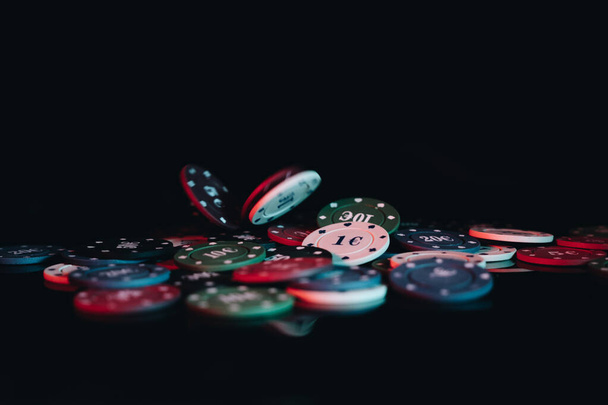 A closeup shot of gambling chips on the black background - Photo, Image