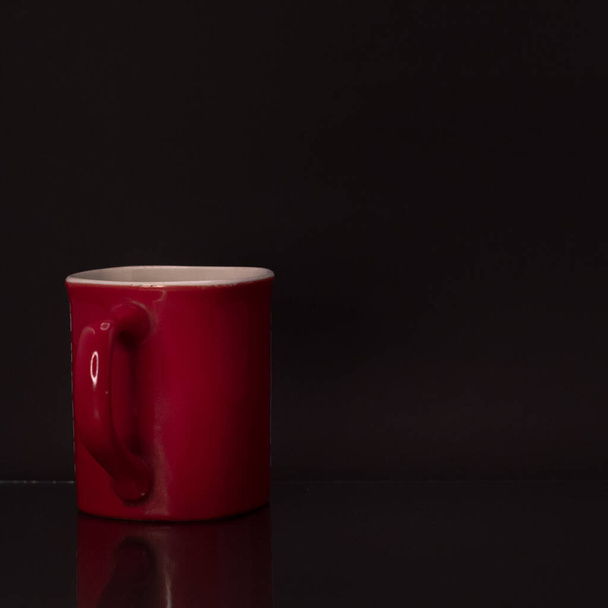 An indoors studio shot red tea cup or coffee cup isolated on black background - Fotografie, Obrázek
