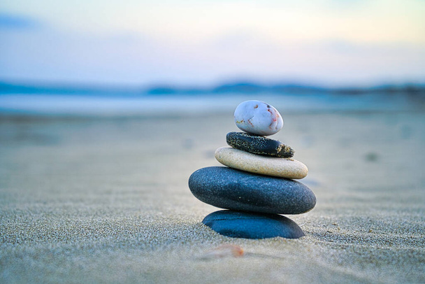A closeup shot of stone stacking on a sand - Фото, изображение