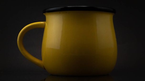 A close up side shot of a yellow ceramic mug isolated - Zdjęcie, obraz