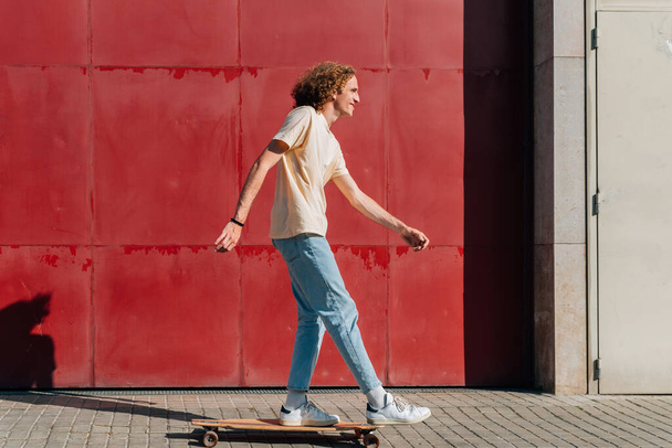 Молодой человек катается по городу в летний день - Фото, изображение