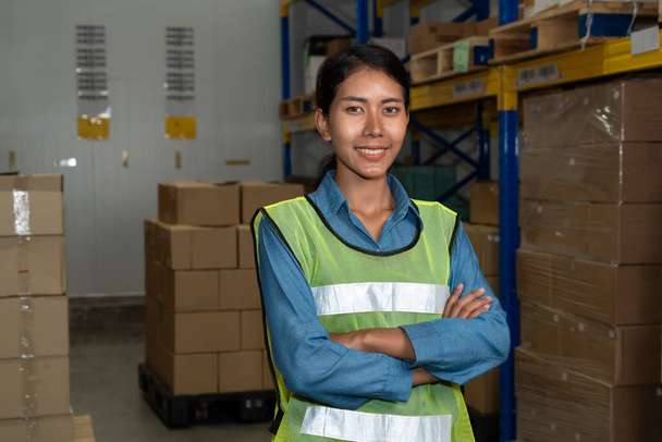 Portrait of young woman warehouse worker smiling in the storehouse - Photo, Image