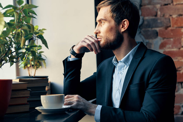 üzletember öltönyben ül egy kávézóban szabadidő menedzser pénzügy - Fotó, kép
