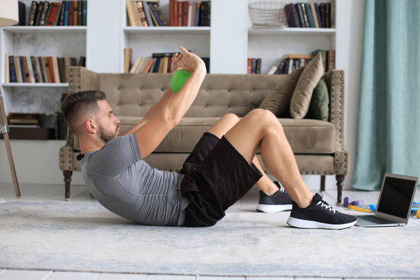 Handsome man doing sport exercise with kettlebell at home. Concept of healthy life - Fotografie, Obrázek