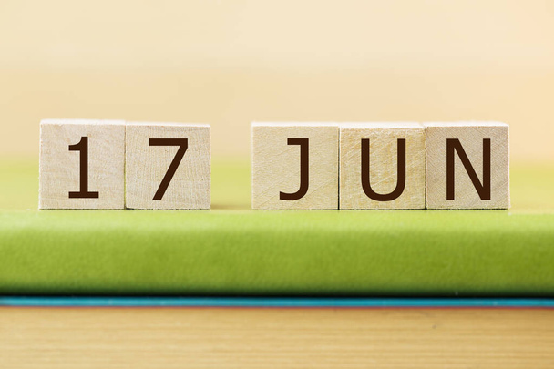 Wooden cubes calendar for 17 JUNE on green book, closeup - Fotografie, Obrázek