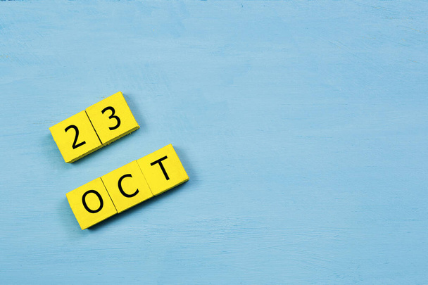 Календар жовтих кубів на синій дерев'яній поверхні з 23 OCTOBER і пробілами для копіювання
 - Фото, зображення
