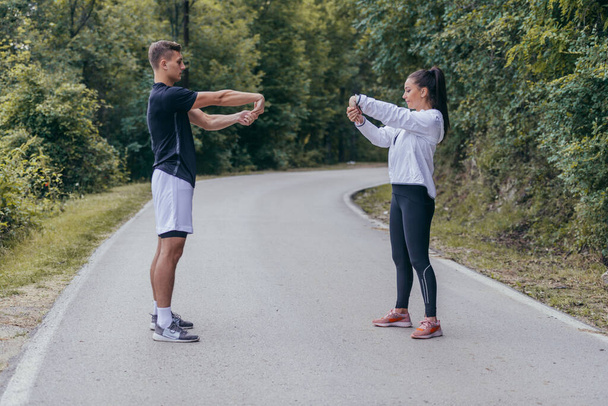 Atletas masculinos y femeninos preparándose para un maratón, correr, hacer ejercicio. concepto de estilo de vida saludable. - Foto, Imagen