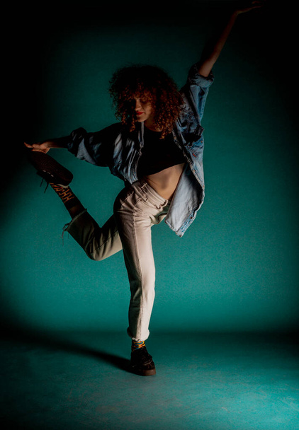 Νεαρή αθλητική κοπέλα εκτελεί σύγχρονες χορευτικές κινήσεις - Φωτογραφία, εικόνα