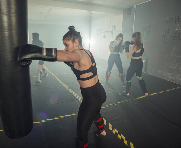 Bokserka. Boks fitness kobieta uśmiechnięta szczęśliwy noszenie czarnych rękawic bokserskich. Portret sportowy dopasowany do azjatyckiego modelu siłowni bokserskiej - Zdjęcie, obraz