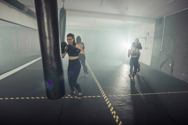 Genç ve seksi kadın kickboks yaparken arka bacağına tekme atıyor.. - Fotoğraf, Görsel