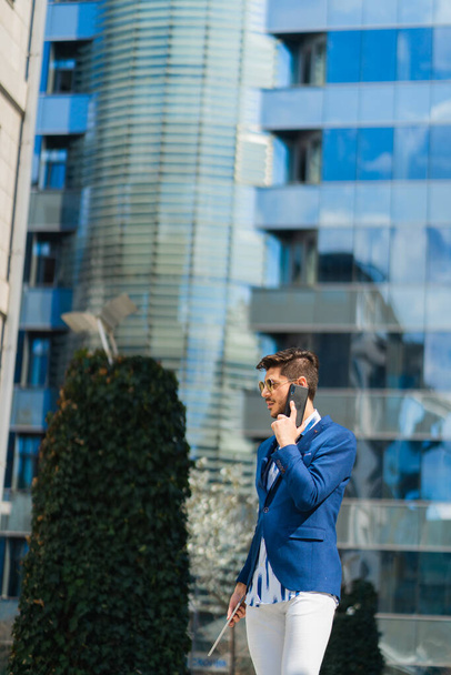 Hombre de negocios bien adaptado está pensando mucho en la conversación que está teniendo con sus socios en el teléfono para su compañía - Foto, Imagen