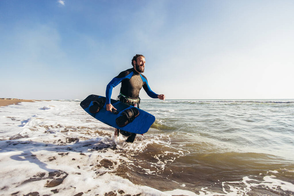 Surfer άνθρωπος με σανίδα του σερφ στην παραλία. Θερινή αθλητική δραστηριότητα - Φωτογραφία, εικόνα