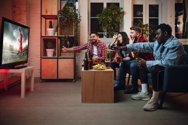 Group of friends watching TV, sport match together. Emotional fans cheering for favourite team, watching on exciting game. Concept of friendship, leisure activity, emotions - Foto, Bild
