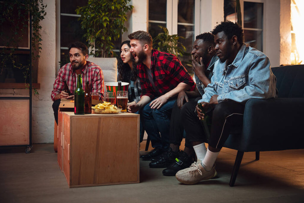 Group of friends watching TV, sport match together. Emotional fans cheering for favourite team, watching on exciting game. Concept of friendship, leisure activity, emotions - Fotoğraf, Görsel