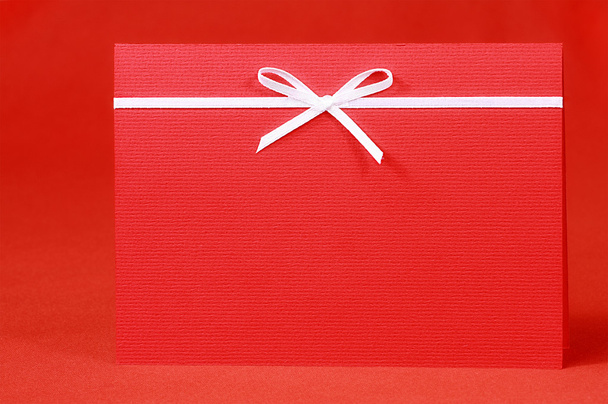 Red invitation card with bow on red silk satin background - Valokuva, kuva