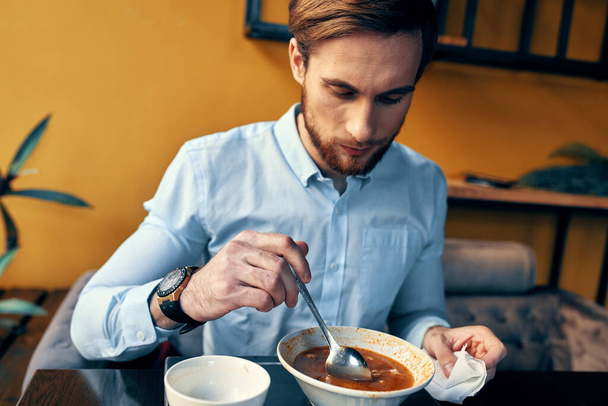 Man eating borscht and pilaf cafe restaurant interior business finance shirt model - Фото, зображення