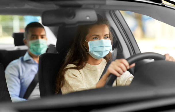 female driver in mask driving car with passenger - Φωτογραφία, εικόνα