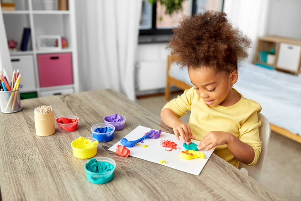 little girl with modeling clay playing at home - Photo, image