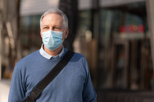 Masked businessman walking outdoor to go at work, coronavirus people lifestyle concept - Fotografie, Obrázek
