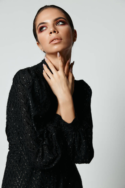 mujer bonita vista lateral vestido negro posando vista recortada de modelo - Foto, Imagen