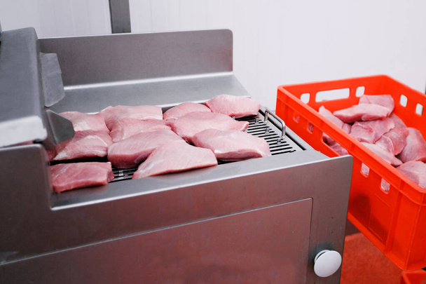 Coupes fraîches et crues de viande hachée, introduites dans un lavage d'introduction dans le processus de production de viande. Vue horizontale. - Photo, image