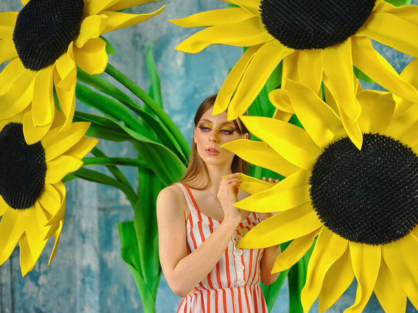 Girl in a summer dress among sunflowers - Foto, afbeelding