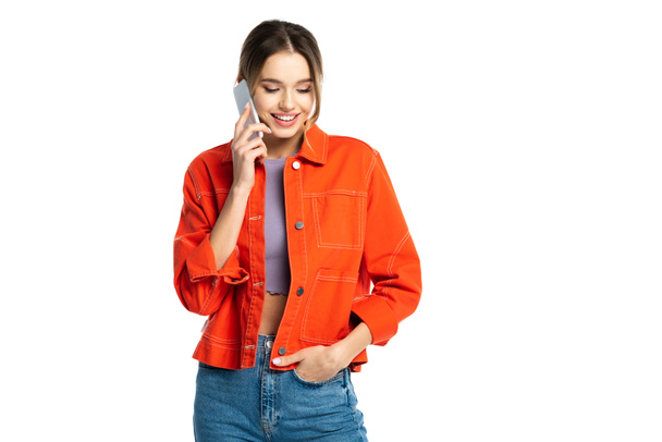 щаслива молода жінка в джинсах і помаранчевій сорочці розмовляє на смартфоні ізольовано на білому
 - Фото, зображення